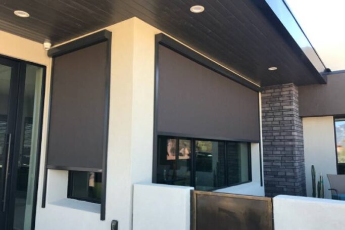 Exterior solar screens covering the exterior windows of a home.