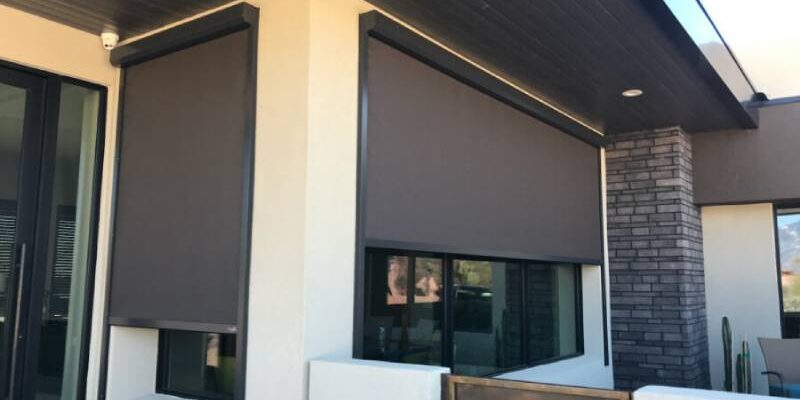 Exterior solar screens covering the exterior windows of a home.